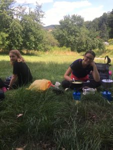 Fotka dvou účastnic expedice sedících u oběda v trávě